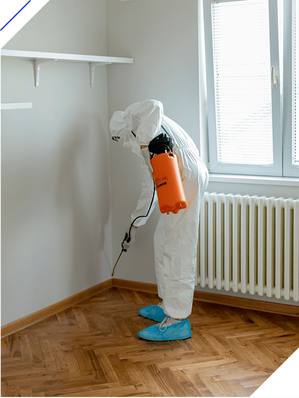 Man in chemical protection suit and face mask disinfecting or spraying empty