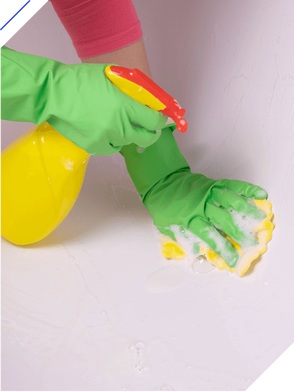Girl cleans the bathroom and washes the bath with detergent