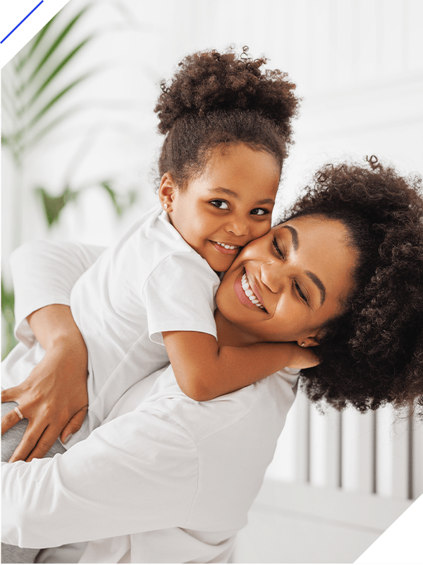 African american mother and daughter play and laugh in bed