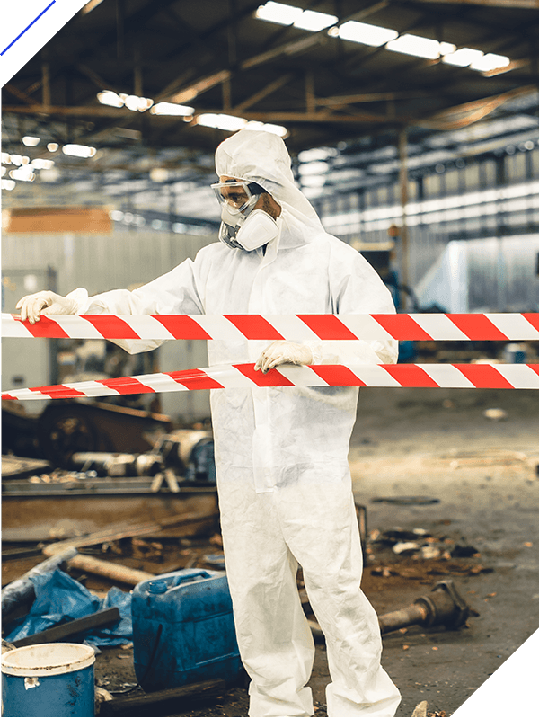 Worker in safety suit with area closed barricade security tape in danger dirty area
