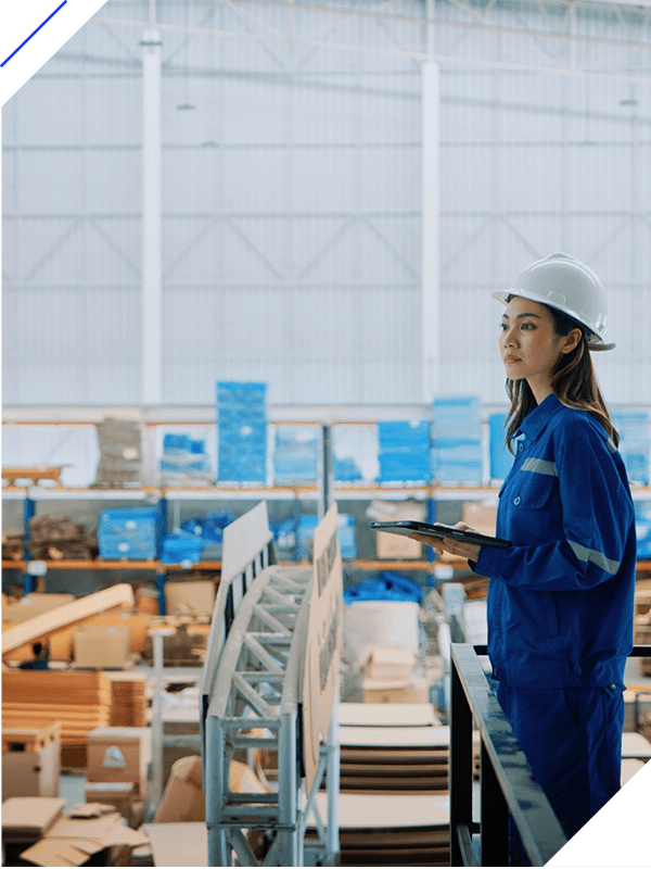 Female engineer in a hardhat and uniform supervising warehouse operations