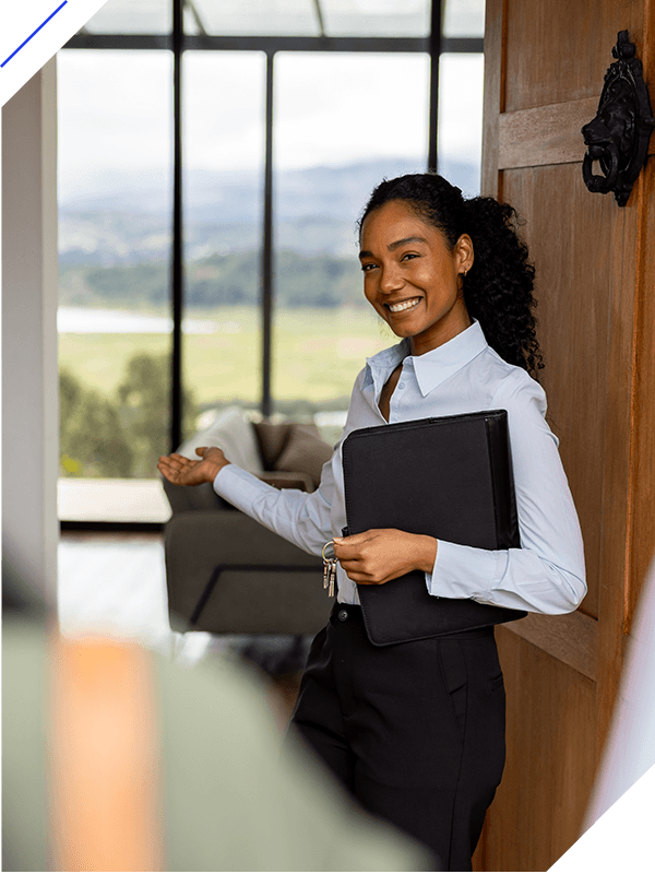 Happy real estate agent welcoming clients to a house